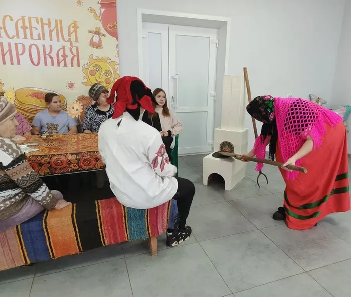 ведущая достает блины из печи горячей