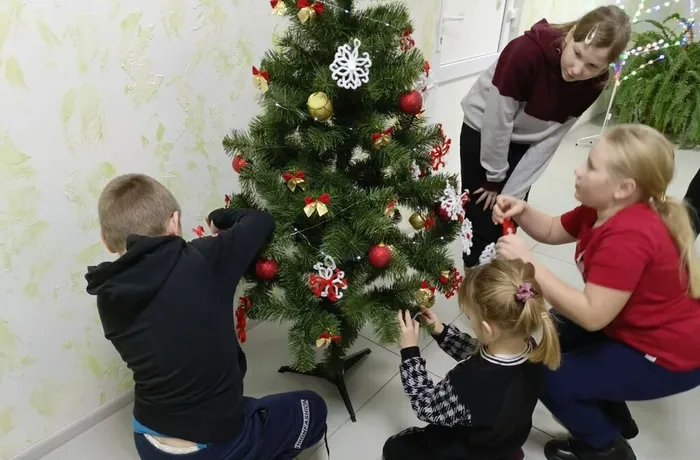 Дети повешали снежинки на елку