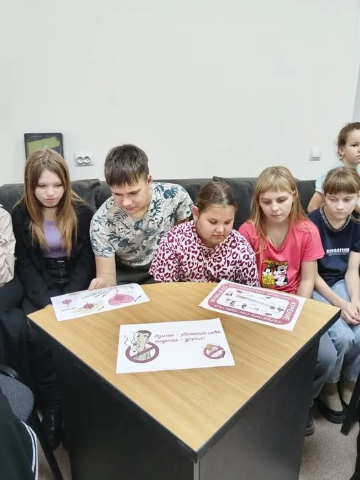 дети рассматривают листовки о вреде курения